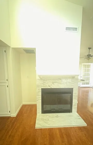 View from living space. New fireplace and custom mantle. Cavity to the left has the HVAC controls and is great for a bar, entertainment system or additional storage. Dining nook and balcony doors to the far right. Entrance to bedroom hall to the left.