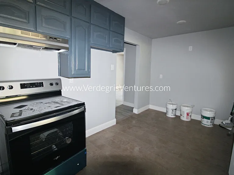 The kitchen is modest in size yet functional, featuring granite counters, stainless steel sink and appliances, a west_facing window for natural light, and direct access to the carport