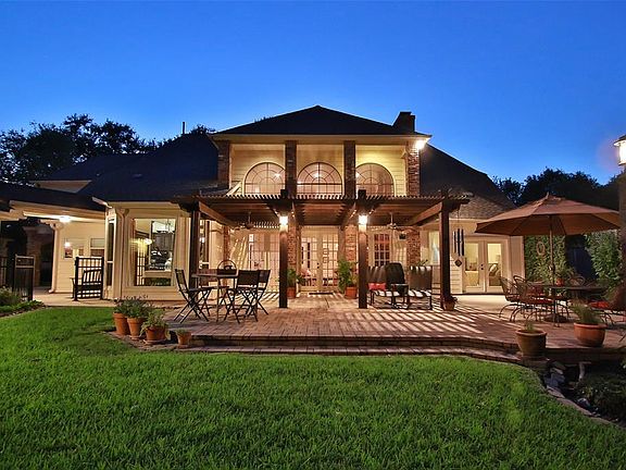 REAR YARD WITH PARK-LIKE SETTING. Numerous lounge areas are in this backyard paradise. To the left is the garage entrance. Behind the garage area tucked away to the side is a perfect spot for growing your own vegetables.