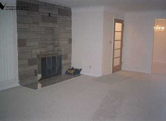 Large living room with new caroeting and woodburning fireplace