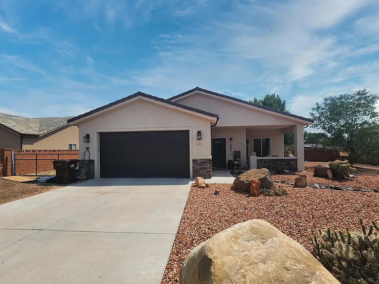 Front of Home with front landscaping and expansive driveway, street parking available as well