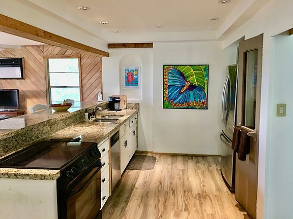 Le kitchen with granite countertops, art niche, long granite bar, dishwasher, gecko handles, old phone booth door pantry _ unique accents