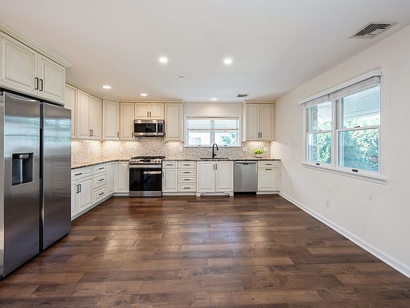 Spacious, sun-filled open kitchen and dining area with rich refurbished hardwood flooring. Recessed lights. Stainless steel appliances
