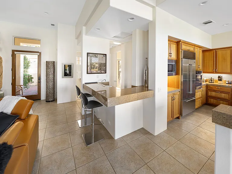 Great room looking toward front door with bar and kitchen on right