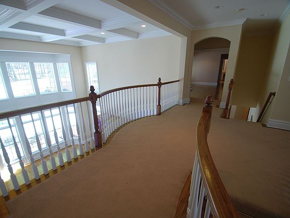 Second floor hallway with balcony overlooking foyer and family room