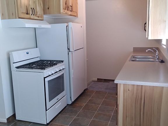Kitchen with new cabinets, stove, dishwasher, and flooring