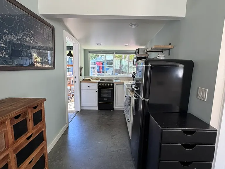 From dining area, looking toward kitchen and door (on left).