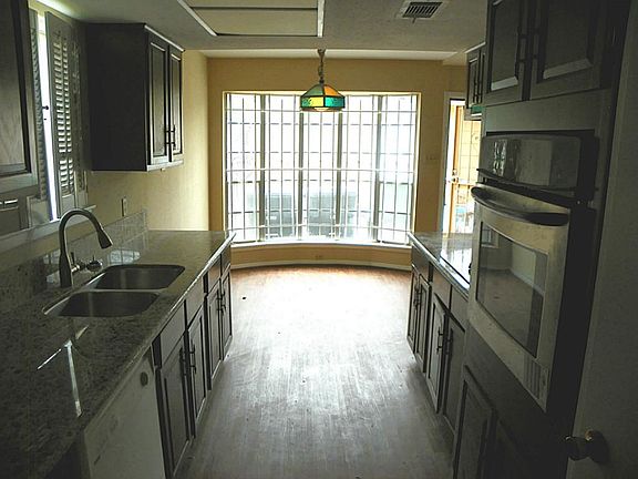 Newly installe granite countertops in kitchen with stainless steel oven/sink/faucet
