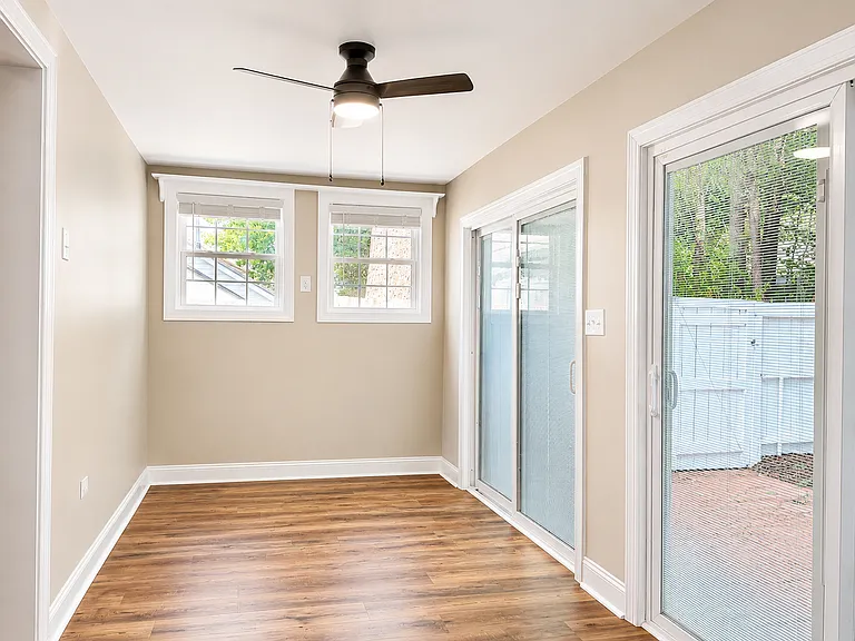 Enclosed sunroom at the back of the house, leading out to the backyard.