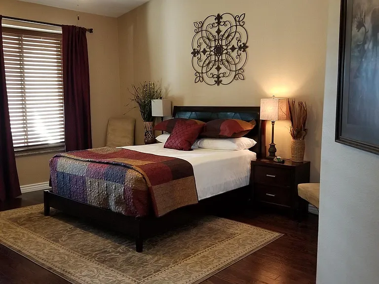 Master bedroom with queen bed, two night stands, dresser, TV