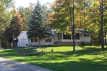 Very well maintained 3 bedroom home on large (100x400) wooded lot. Newer 26x32 pole barn, great for boat storage. There is a sandy beach easement just steps away. Dry walk-out basement with half bath.  Master bath has been totally redone with ceramic tiled floor. All windows replaced 3 yrs ago. Newer viny in kitchen and carpeting in bedrooms. 5 new remote controlled ceiling fans. 2.5 car attached garage. Nice front screened in porch.