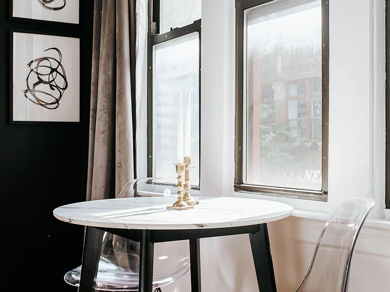 Workspace/Dining nook with a round table for two, large windows, and hardwood floorsideal for meals or a compact workspace.