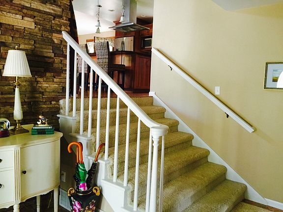 Foyer features an open view of kitchen and extra wide steps to living room.