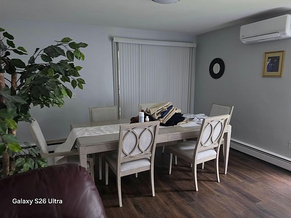 Dedicated dining area with a full-size table for six, set beside sliding doors with vertical blinds for easy light control.