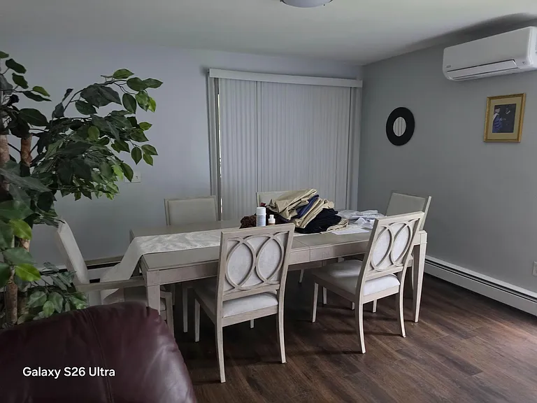 Dedicated dining area with a full-size table for six, set beside sliding doors with vertical blinds for easy light control.