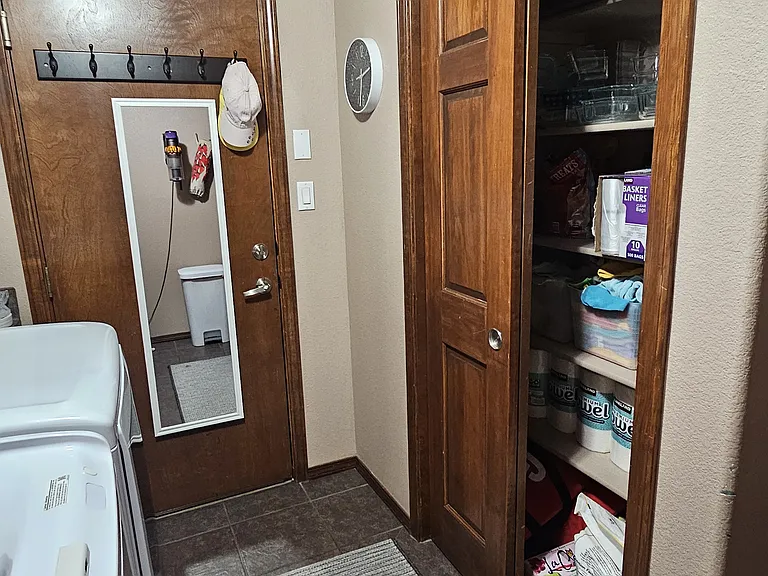 Laundry room with extra storage space, between the garage and kitchen.