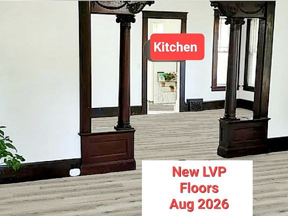 Standing in the foyer looking through the front room to the dining room and the kitchen is beyond. New LVP flooring throughout the house August 2026.