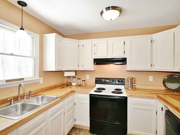 Neutral walls highlight the white kitchen cabinetry and notice all the counter space.  The refrigerator is to the left creating the perfect triangular layout for cooking optimization while the dishwasher makes clean up a breeze. 