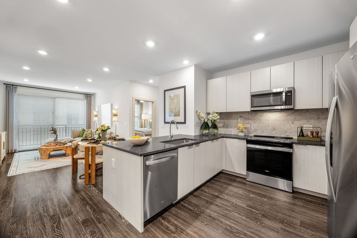 Modern open-plan apartment with stylish kitchen, inviting living area, and elegant decor, perfect for contemporary living.