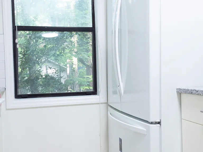 The refrigerator is French door style, with double doors and a bottom freezer.