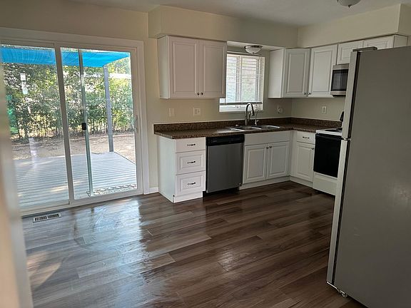 Newly remodeled kitchen with patio leading to shaded back deck