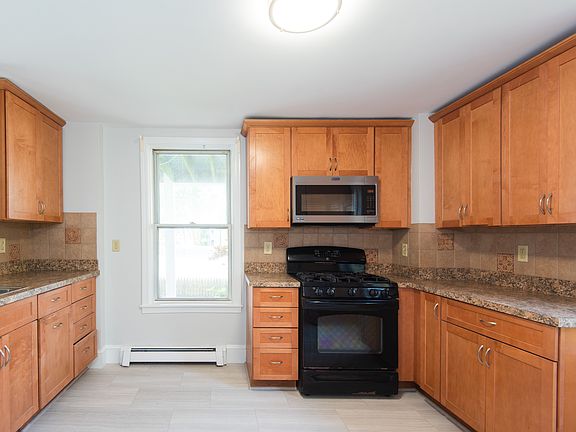 Kitchen featuring new flooring, full fridge/ freezer, oven/ stove, microwave and dishwasher.