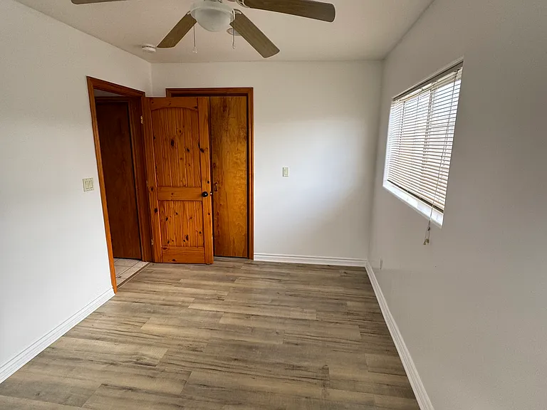 Bedroom showing two panel Pine Solid wood door clear stain.
