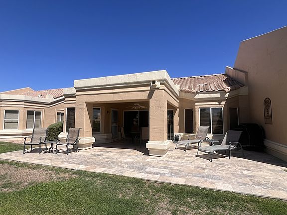 Oversized patio with upgraded natural stone. Seating areas include dining table for 6 and lounge chairs for sunning.