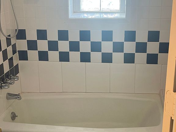 Vintage tile and glass-block windows surround the soaking tub and shower.
