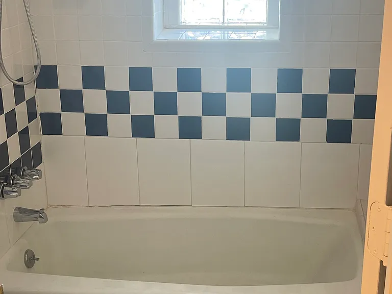 Vintage tile and glass-block windows surround the soaking tub and shower.