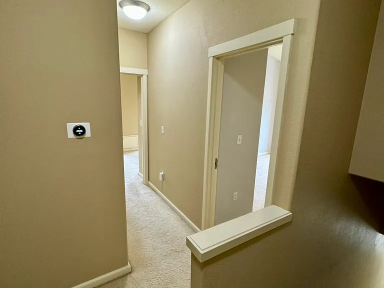 Bedroom floor with 2 beds, 2 full baths, and smart home thermostat