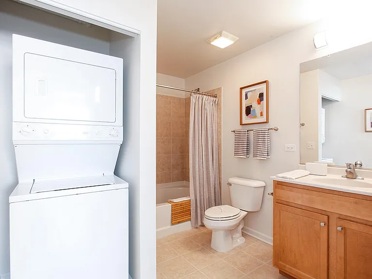 Full bathroom with shower-tub combo and stacked laundry