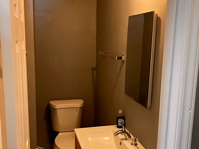 Hallway bathroom with bath tub & tiled shower.