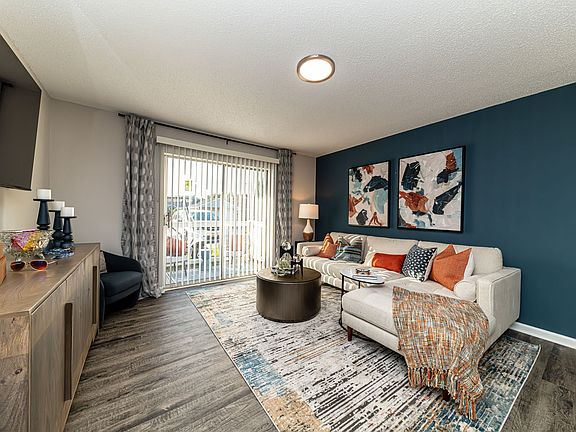 Spacious living room with hardwood-style flooring & overhead lighting