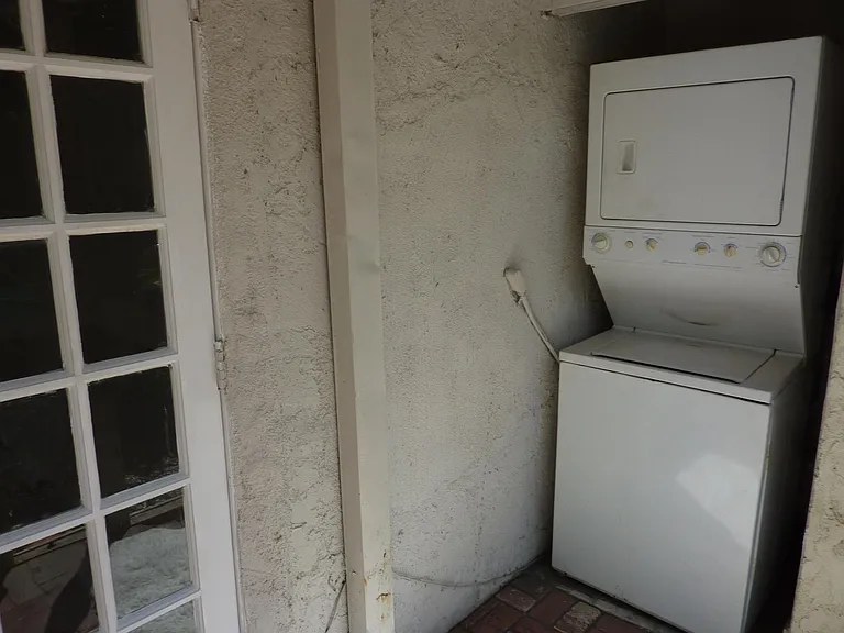 Stacked washer dryer in protected area just outside your front door! Enjoy your private patio while doing your laundry!