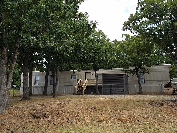 Front of mobile home with 8x16 front porch & 11x9 shed.