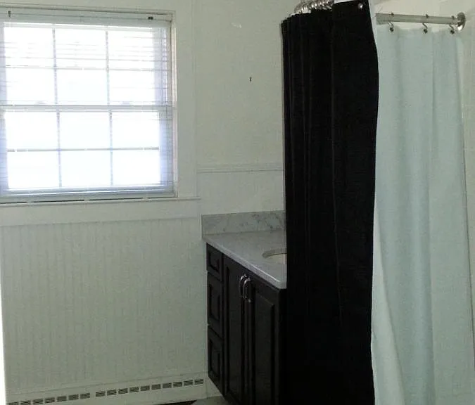 Main Bath - tub, shower, vanity, toilet & cupboards for storage.