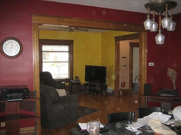 This is a picture taken just in front of the kitchen through the RED dining room looking towards the living room and foyer. Did I mention the foyer has its own bike rack! In the background one can see the leaded glass transom window.