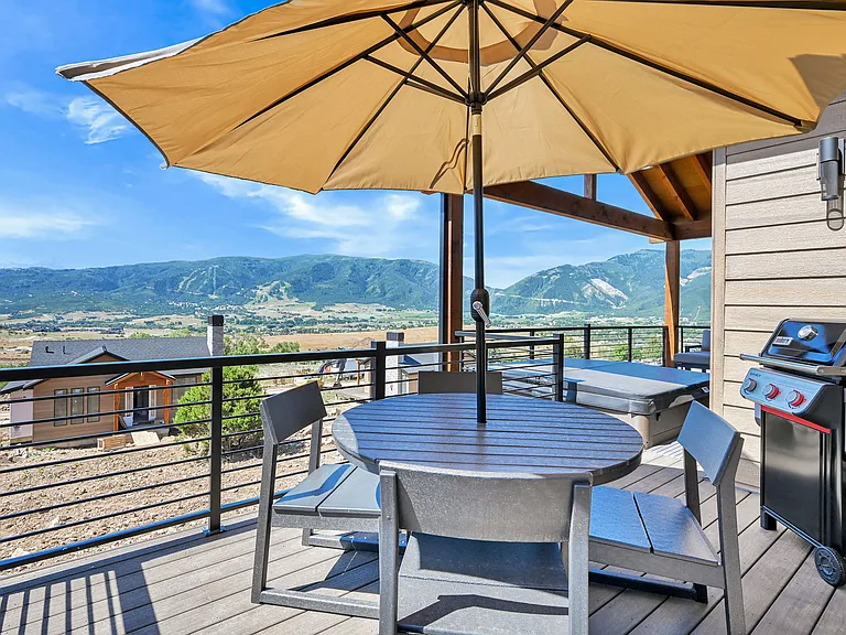 Deck with patio furniture, umbrella, gas grill, and private hot tub