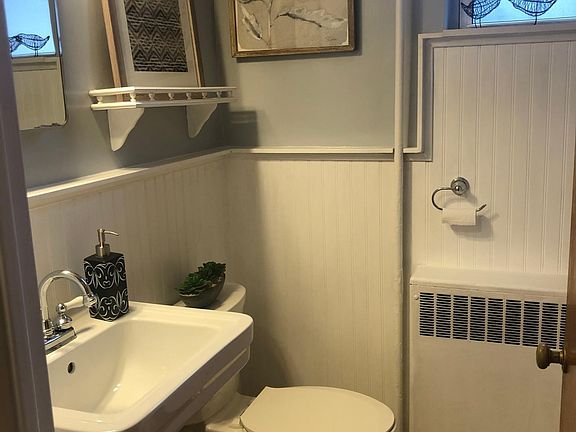 Fully updated bathroom with tile flooring & tub/shower combo, pedestal sink, medicine cabinet & toilet.