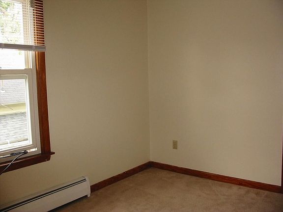 Small bedroom with a large closet with shelving at one end.