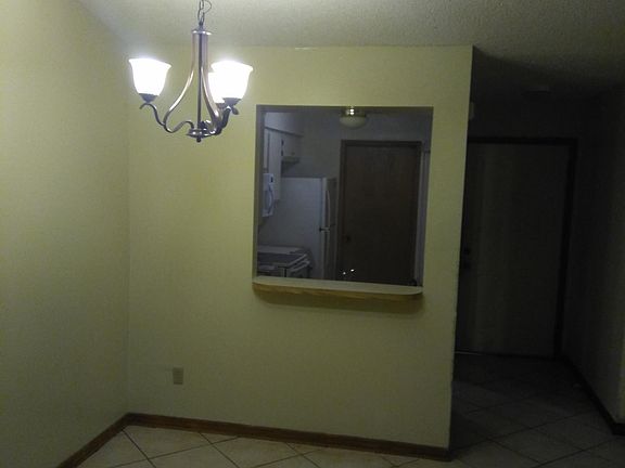 Dining room and breakfast counter with view of kitchen and laundry room door and entrance door on right