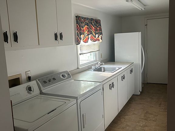 utility room opposite wall has three long rows of shelves for storage and a closet