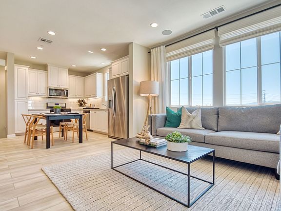 An image of the great room with a view of the kitchen and dining space in the Citrus Plan 1 Model Ho