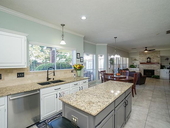 There is an island with extra storage. A double sink faces the back yard. You can see how open the kitchen is to the breakfast area and family room.