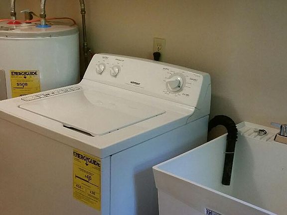 Laundry room includes washer, dryer, laundry tub and storage cabinets