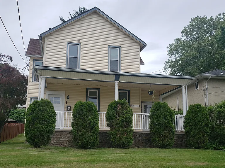 Front of house. Front door on left side of porch