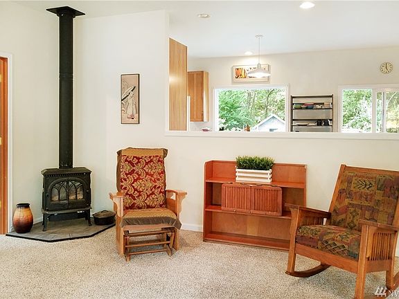 Living room smoothly transitioning into the kitchen with a peak-a-boo view of the backyard.