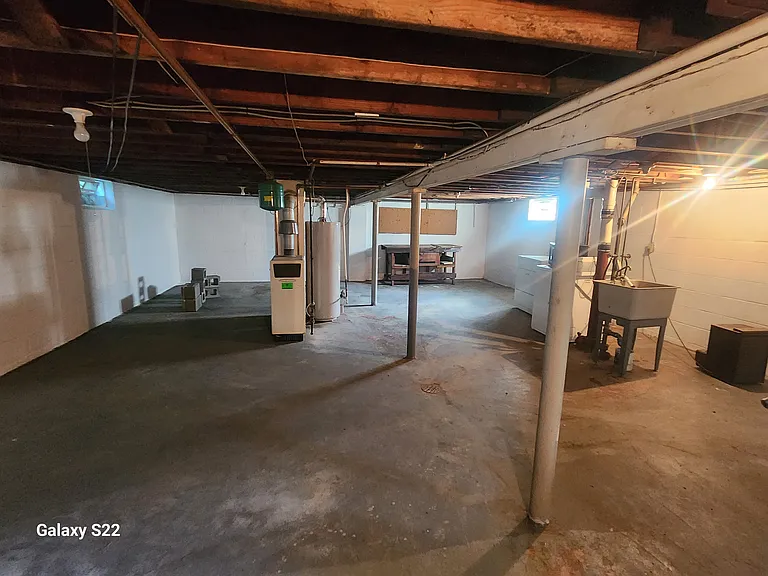 Basement area with washer, dryer, and slop sink.