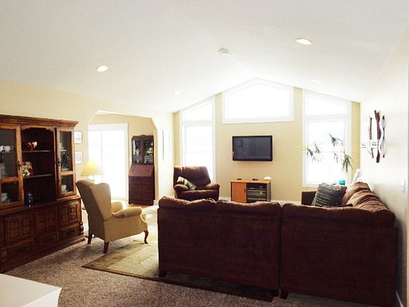 Living room with plenty of windows to let the sun shine in. Cathedral ceiling and open to the dining area.
